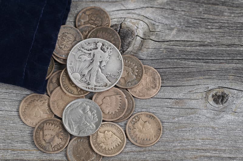 Numismatic coins thrown on the table from open pouch.